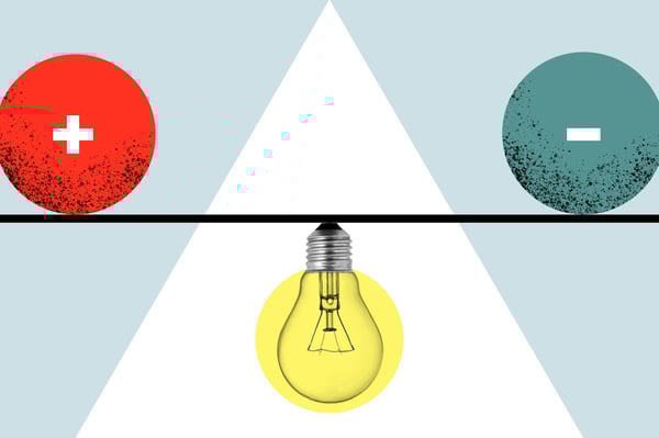 los signos más y menos se equilibran en una línea con la base de una bombilla